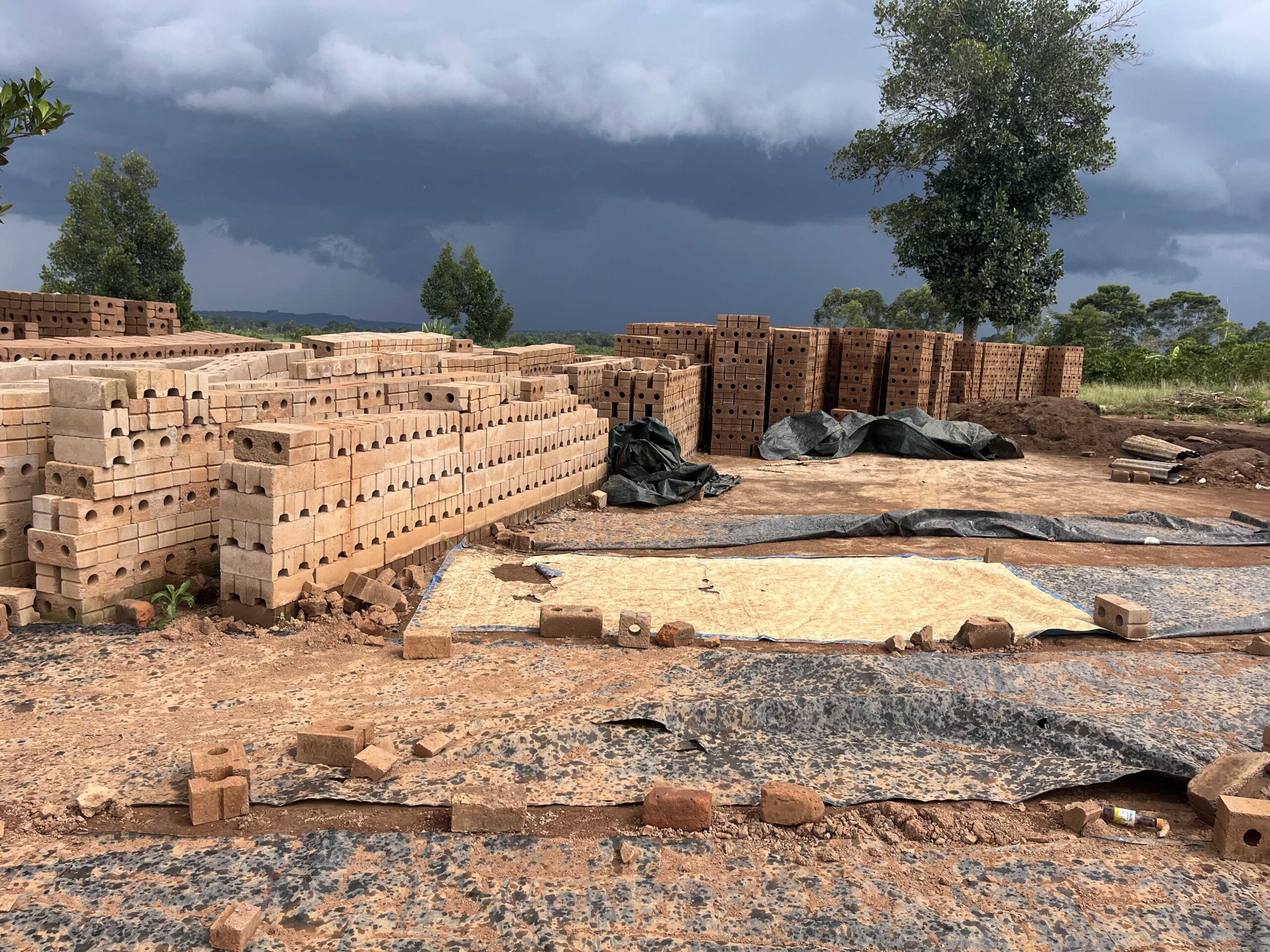 A row of modern homes with large windows and small balconies. The buildings showcase a clean architectural design with white and red detailing. The sky is clear and blue, illuminating the facade of the houses.